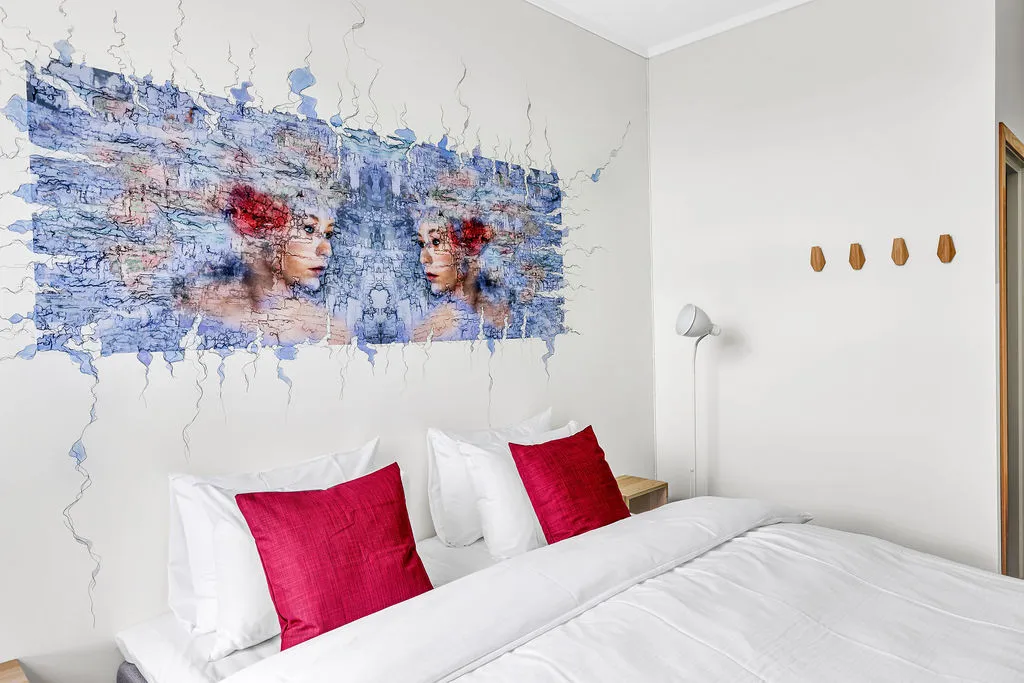 Standard-rom med fargerik kunst over sengen